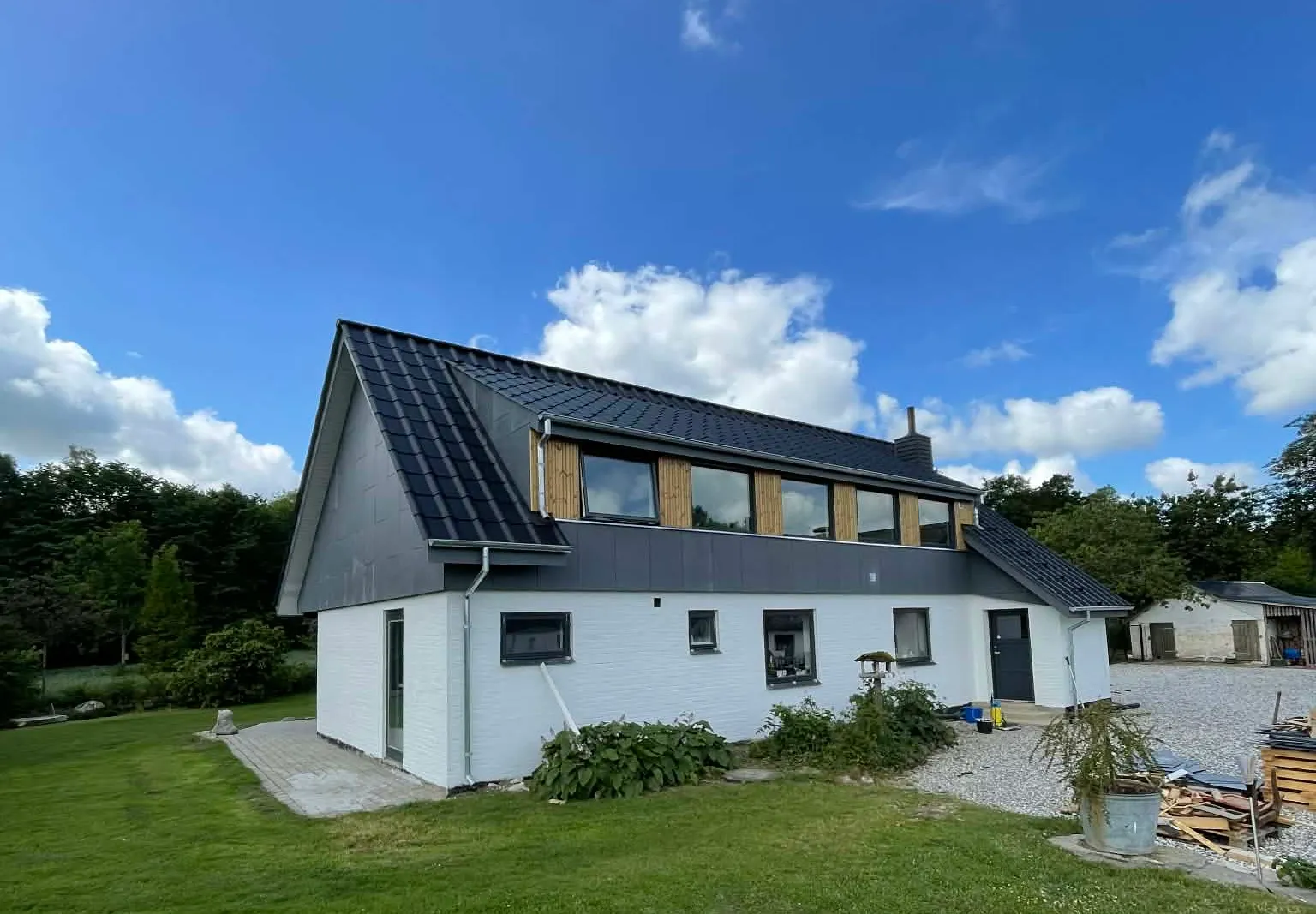 Hvid villa med nyt mørkt tegltag og vinduesbånd udført af Brix Byg